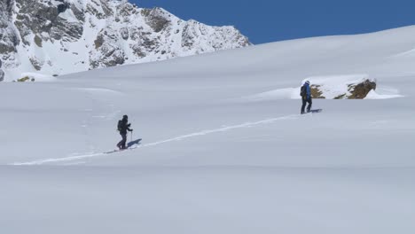 Zwei-Skiwanderer,-Trekking-Im-Tiefen-Schnee-Auf-Einem-Alpenpfad,-Heller-Wintertag-In-Den-Alpen---Statische-Aufnahme