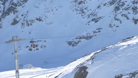 Ski-lifts-moving-up-to-the-snowy-alpines-high-in-sunny-Kaunertal,-winter-in-Austria---static-view