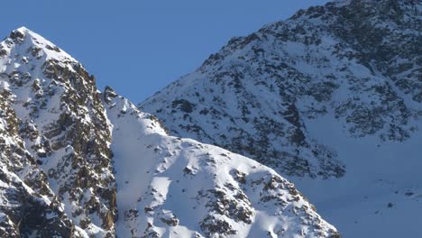 Schneebedeckte-Und-Felsige-Bergwände-In-Den-Sonnenbeschienenen-Alpen-Tirols,-österreich---Neigungsansicht