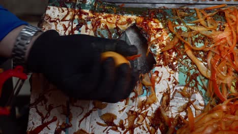 Close-up-person-using-peeling-machine-to-peel-persimmon,-making-dried-persimmon,-Vietnam