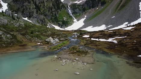 Flying-low-above-turquoise-crystal-clear-alpine-lake,-aerial-shot,-West-Kootenays,-1-of-2