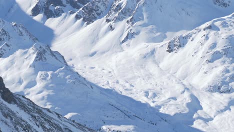 Nieve-Profunda-En-Las-Paredes-De-Las-Montañas-Iluminadas-Por-El-Sol-En-Los-Alpes-Del-Tirol,-Austria---Vista-Panorámica