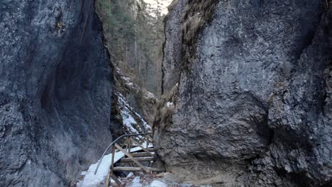 Fly-Away-At-Steep-Rock-Mountains-With-Wooden-Bridge-During-Winter
