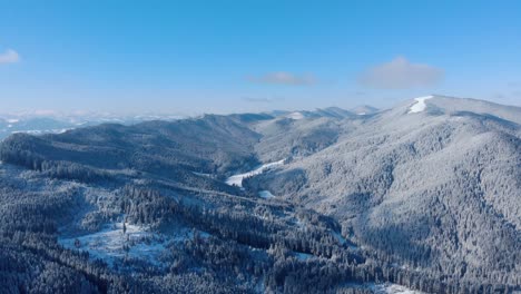 Malerischer-Blick-Auf-Schneebedeckte-Berge-Mit-Kiefern-Vor-Blauem-Bewölktem-Himmel---Drohnenaufnahme-Aus-Der-Luft