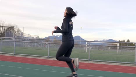Toma-De-Seguimiento-De-Cardán-De-Una-Mujer-Asiática-Corriendo-En-Una-Pista-De-Atletismo