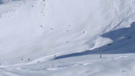 Ski-lifts-high-in-the-snowy-mountains-of-sunny-Kaunertal,-winter-in-Austria---left-pan-shot