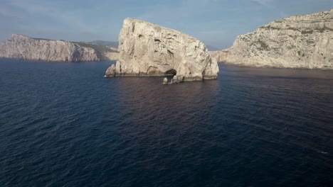 The-aerial-wide-orbit-of-the-cliffs-of-the-Capo-Coccia-near-Neptune's-Grotto-in-Sardinia,-Italy