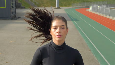 Beautiful-Athletic-Woman-Running-on-the-Track,-Frontal-Shot,-Dolly-Out