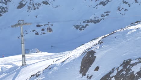 Ski-lifts-moving-up-and-down-in-the-highlands-of-sunny-Kaunertal,-winter-in-Austria---static-view