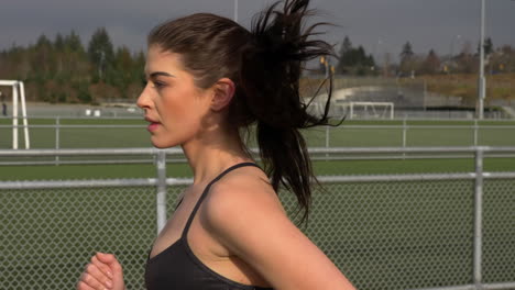 Girl-in-Revealing-Sportswear-Runs-on-the-Track,-Slow-Motion-Tracking