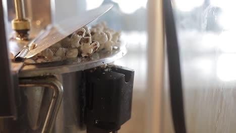 Close-shot-of-popcorn-coming-out-of-pop-corn-machine