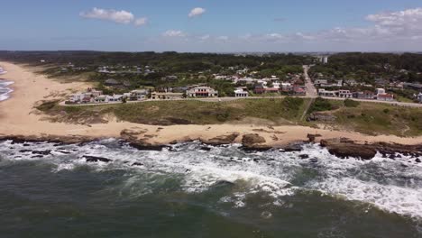 Waves-breaking-on-rocky-coast-of-La-Pedrera-village-on-sunny-day,-Uruguay