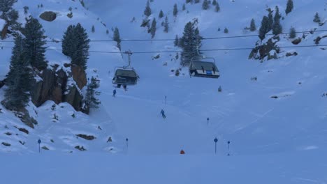 Ski-lifts-moving-up-and-down-while-skiers-ride-downhill-on-the-slopes-of-Kaunertal,-Austria---static-view