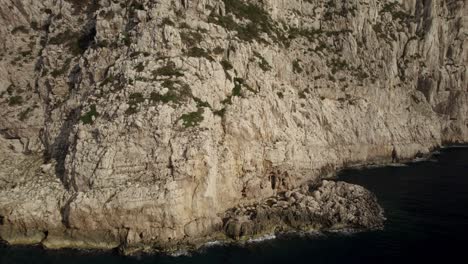 Aerial-close-orbit-over-the-cliffs-of-Capo-Coccia,-Sardinia,-Italy
