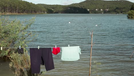 Colorful-clothes-hang-on-clothesline-at-riverside,-Countryside-environment