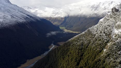 Incredible-valley-with-snowy-mountains-above-with-a-river-running-through-on-a-cloudy-day-in-New-Zealand