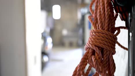 Red-security-nylon-rope-tied-in-a-bundle-at-a-warehouse,-Close-up-pan-left-shot