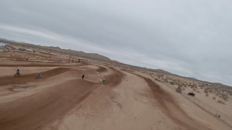 Motorcycles-racing-on-an-off-road-racetrack-in-the-Mojave-Desert---aerial-first-person-view