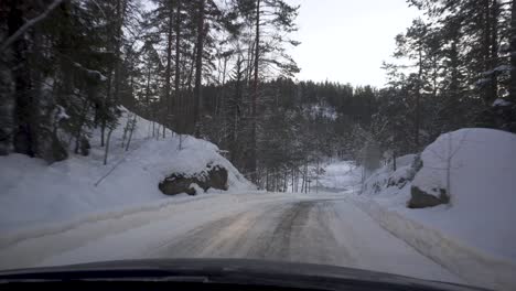 Car-Driving-On-Snowy-Road-In-The-Forest-During-Winter---POV