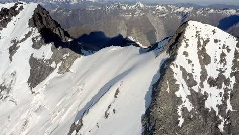Enorme-Montaña-Con-Roca-Y-Nieve-En-La-Cima-Entre-Una-Espectacular-Cadena-Montañosa-Muy-Por-Encima-De-Los-Valles-En-Nueva-Zelanda-Durante-El-Amanecer