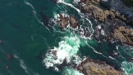 Topdown-Of-Foamy-Waves-Splashing-Over-Outcrops-In-Big-Sur-Coastline-In-California,-USA