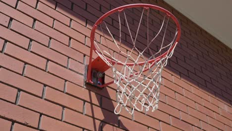 Up-close-shot-of-basketball-ring-with-ball-circling-metal-ring-and-going-into-net-to-score-a-goal