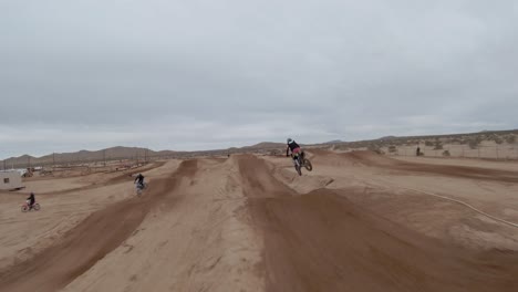 Amazing-high-speed-race-on-dirt-bikes-around-a-track-in-the-Mojave-Desert---first-person-aerial-view