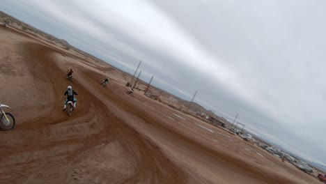 Mit-Einer-First-Person-Drohne,-Um-Motocross-Motorräder-Zu-Verfolgen,-Während-Sie-Um-Eine-Strecke-In-Der-Mojave-Wüste-Rasen