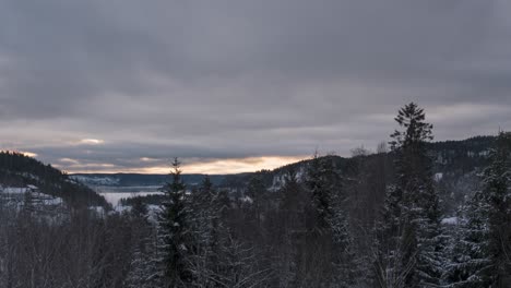 Snowy-Forest-In-The-Mountain-With-Fluffy-Clouds-In-The-Sky-At-Dawn