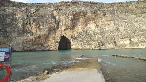 Inland-Sea-Caves-Are-With-Beach-Safety-Information-Sign-and-Lifebelt-Hanging-on-Board