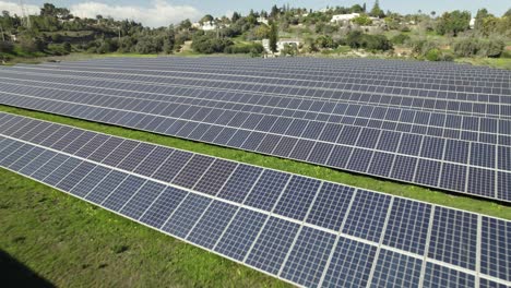 Tiefflug-über-Photovoltaik-Farm,-Sonnenkollektoren-Auf-Rasenfläche
