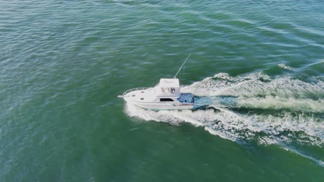 Ein-Kleines-Fischerboot-Bewegt-Sich-Schnell-Mitten-In-Der-Luftaufnahme-Des-Ozeans-|-Drohnenaufnahme-Eines-Kleinen-Fischerbootes,-Das-Sich-In-Der-Mitte-Des-EA-Videohintergrunds-In-4k-Bewegt