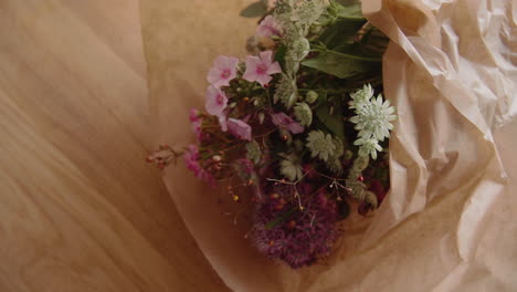 Schöner-Bunter-Blumenstrauß,-Der-Auf-Eine-Holztischplatte-Gelegt-Wird