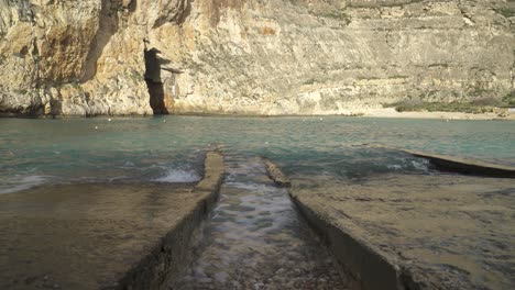 Türkisfarbenes-Wasser-Wäscht-Reihen-Aus-Stein-Und-Gefüllten-Kieselsteinen-In-Der-Nähe-Von-Meereshöhlen-Im-Landesinneren-Auf-Malta