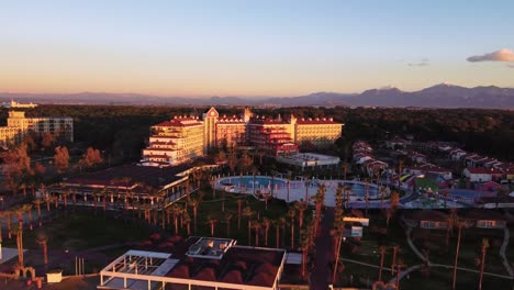 Resort-De-Vacaciones-De-Lujo-Con-Piscina-Y-Palmeras,-Toma-De-Drones-Al-Amanecer