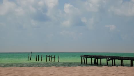 Long-shot-of-a-broken-wooden-boardwalk-on-the-vast-horizon-of-the-between-the-blue-sea-and-sky-at-Soksan-Beach-in-Koh-Rong-Island-Cambodia