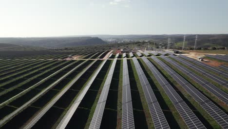 Aerial-pullback-from-photovoltaic-solar-panels,-countryside-Portugal,-Renewable-energy