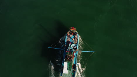 Aerial-birdseye-tracking-shot-of-fisherman-boat-going-out-in-Mui-Ne,-Vietnam