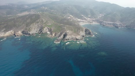 Aerial-trucking-shot-of-the-beautiful-crystal-waters,-and-rocky-coast-of-a-Cape-Argentiera,-Sardinia,-Italy