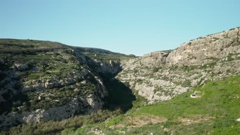 AERIAL:-Flying-In-Canyon-Near-Magrr-Ix-Xini-Bay-on-Gozo-Island-in-Malta