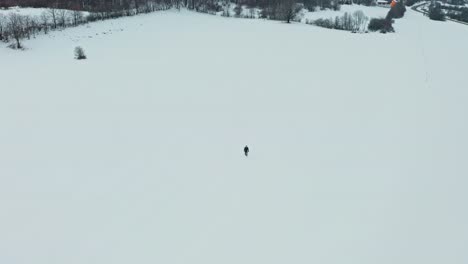 Aerial-drone-shot-of-the-man-walking-in-the-snow-3