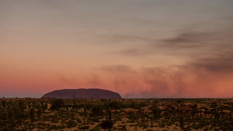 A-time-lapse-of-smoke-from-controlled-bush-fires-blowing-around-Uluru-in-the-Northern-Territory,-Australia