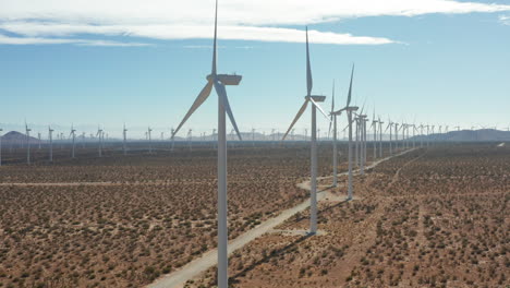 Camera-jibs-up-displaying-a-vanishing-row-of-windmills-at-a-solar-farm