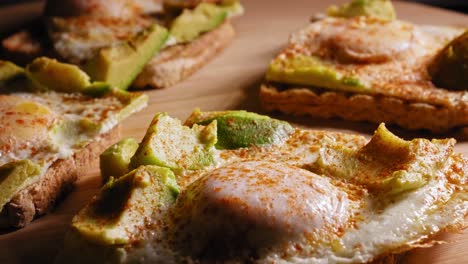 A-close-up-macro-shot-tilting-down-to-reveal-an-amazing-tasty-delicious-egg-and-avocado-on-toast-open-sandwich,-a-simple-yet-easy-to-cook-snack