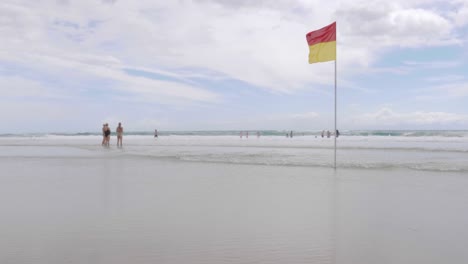 Red-and-Yellow-Flag-Blowing-in-the-wind-on-Beach