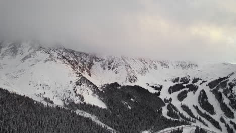 Drone-Aerial-Footage-Of-Rocky-Mountains-Valley-Slope-Covered-In-Pine-Tree-During-Cloudy-Golden-Hour-Sunset-In-Loveland-Pass,-Colorado-USA