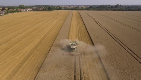 Harvest-rising-tilt-tracking-shot-over-Claas-Harvester-with-crop-dust