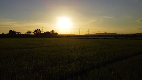 Hellgelber-Sonnenuntergang-Und-Silhouette-Der-ökologischen-Windmühlenfarm,-Luftfliege-Nach-Vorne