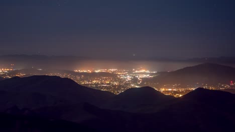 A-time-lapse-taken-from-TV-Tower-Road-in-the-Los-Padres-National-Forest,-looking-at-San-Louis-Obispo-on-a-foggy-night,-California