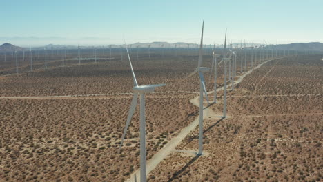 Camera-jibs-up-and-tilts-down-along-vanishing-line-of-windmills-at-a-solar-farm